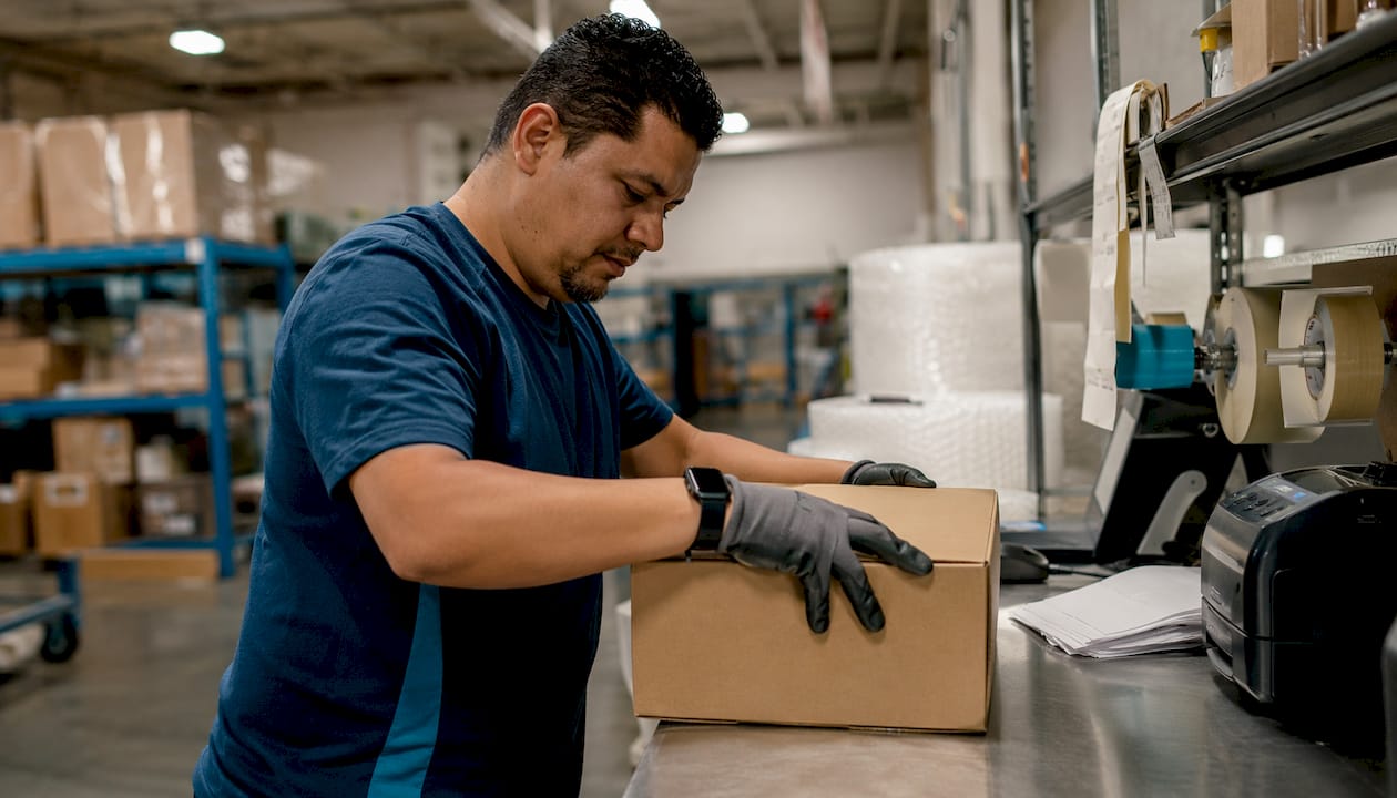 Warehouse worker packing box for shipping
