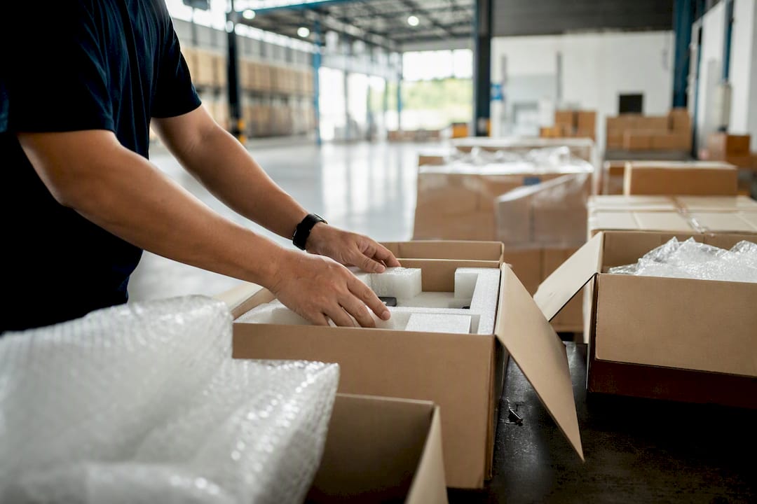 Hands packing cushioning in shipping box