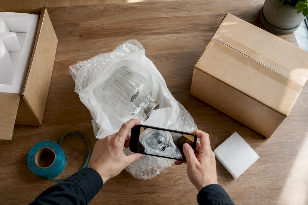 Hands documenting fragile package condition