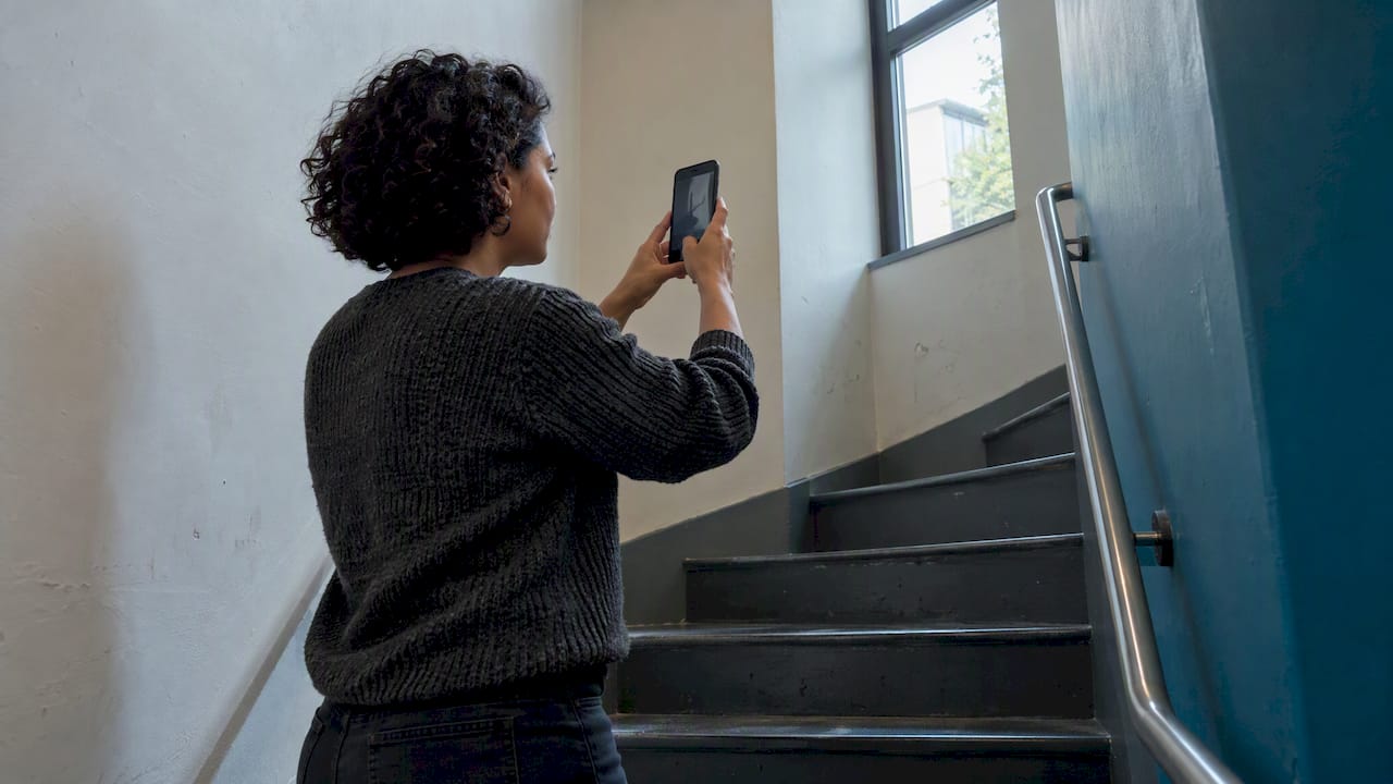 Buyer photographing a narrow stairwell landing